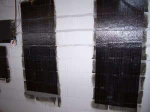 Carbon fiber strips applied to foundation walls, illustrating effective reinforcement for preventing water damage and structural issues.