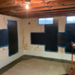 Basement interior showing foundation repair process with black sealant applied to wall cracks, emphasizing the importance of addressing foundation issues for home stability and health.